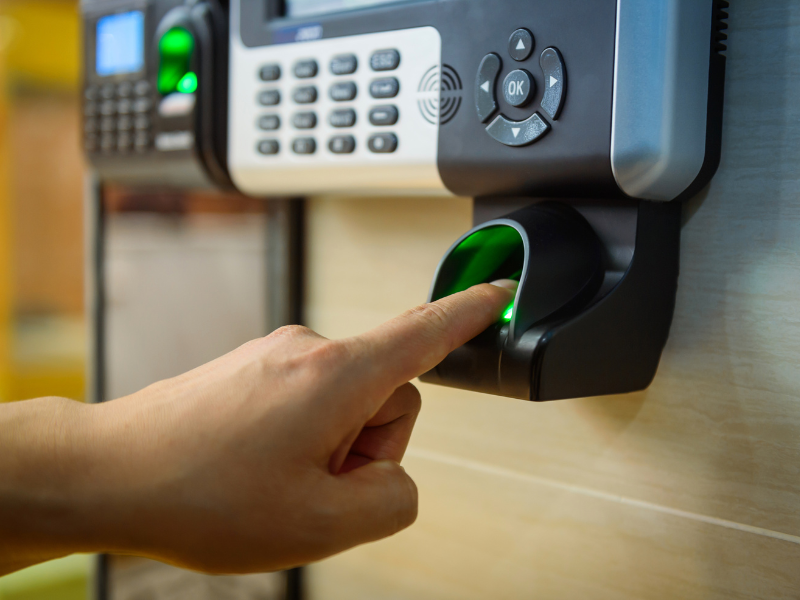 A hand placing a finger on scanner for access control.