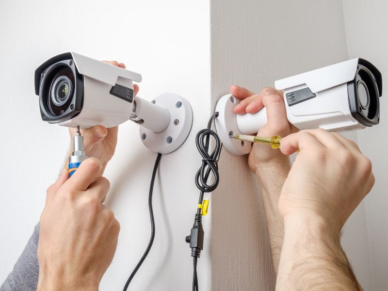 Two pairs of hands installing CCTV cameras for a CCTV System